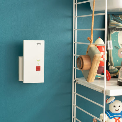 FRITZ!Repeater 2400 an einer Wand in modernem Zuhause, erweitert das WLAN-Signal.